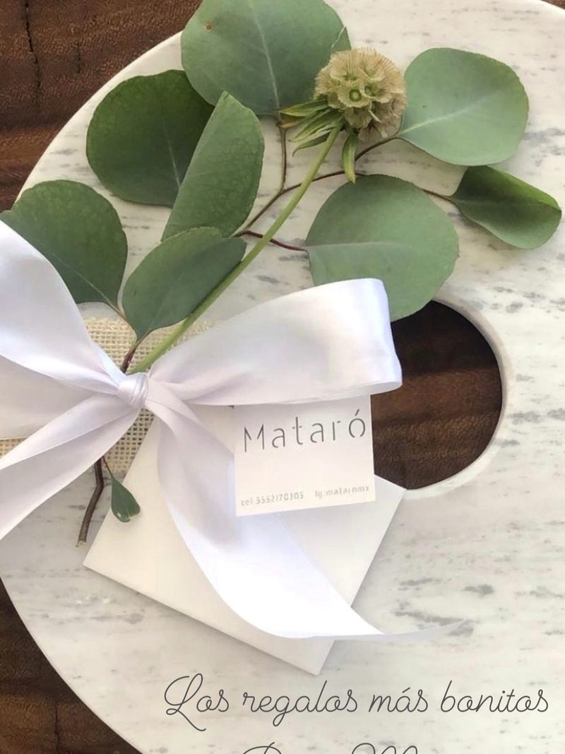 Pieza de mármol blanco con lazo y eucalipto