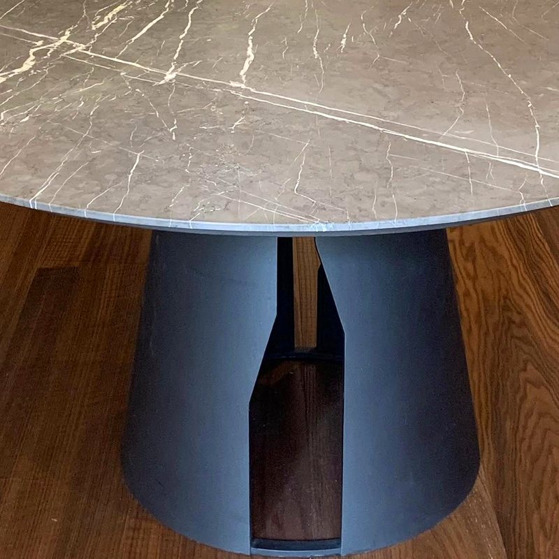 Mesa redonda de mármol gris con base de metal